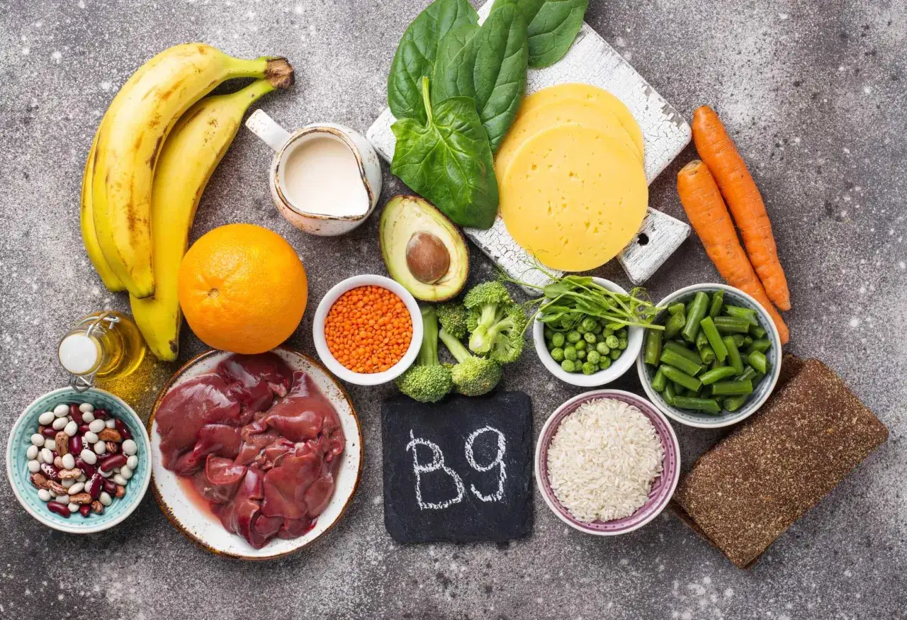 Alimenti ricchi di acido folico (B9), utili per la menopausa: fegato, spinaci, lenticchie, arancia, broccoli, piselli, fagioli, banane, carote, riso, pane integrale, formaggio, avocado, latte.
