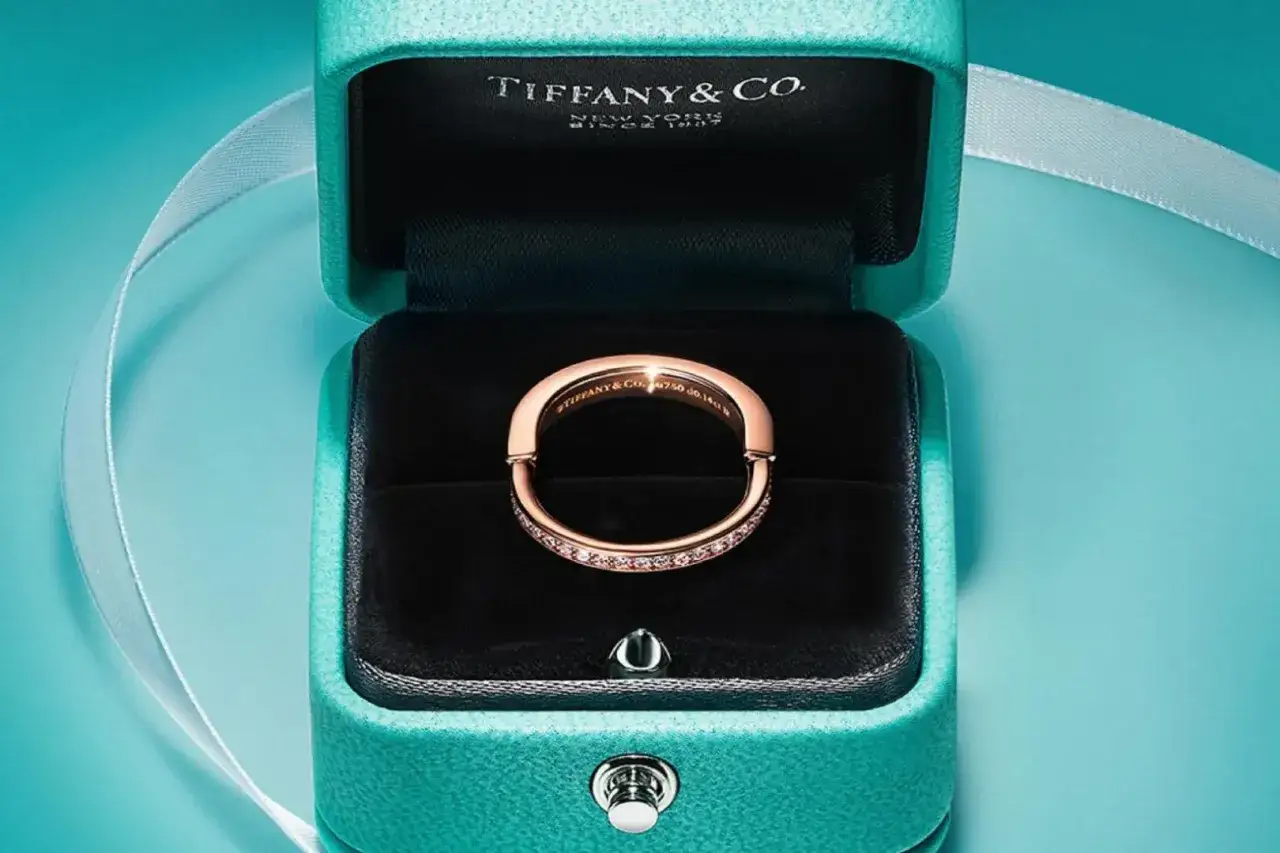 Elegancki pierścionek z różowego złota wysadzany diamentami, w klasycznym pudełku Tiffany & Co. Symbol luksusowych marek biżuterii.