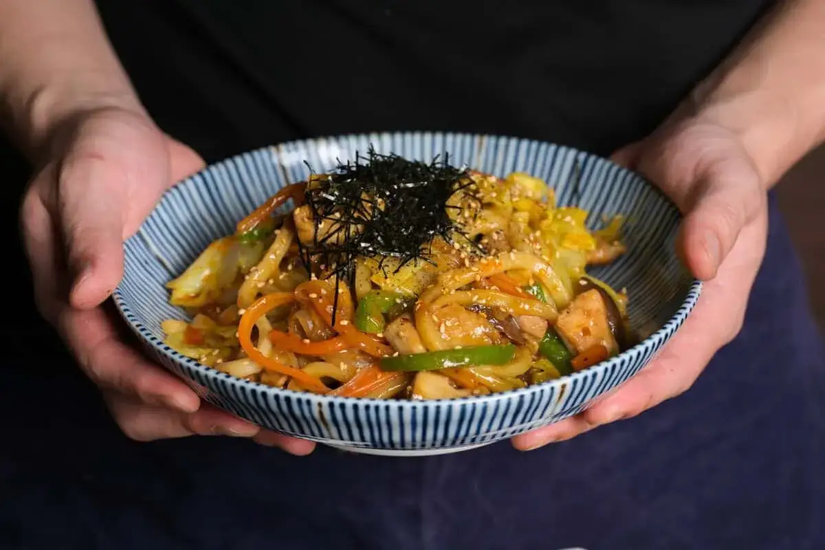 Pyszne udon z kurczakiem, warzywami i posypką z nori.