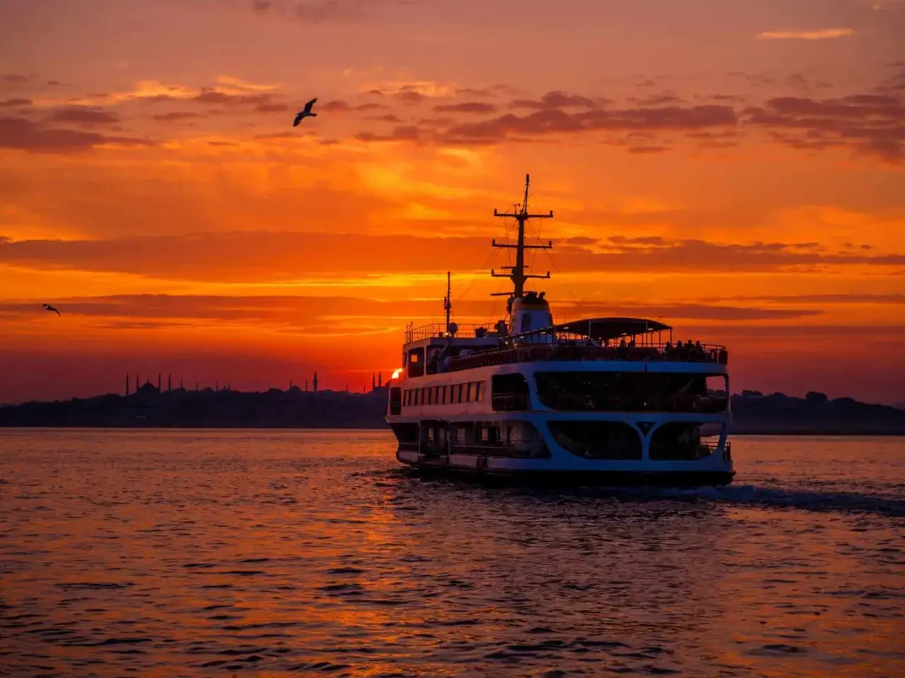 Un ferry navigue sur les eaux d'Istanbul au coucher du soleil. Une belle façon de découvrir que faire à Istanbul.