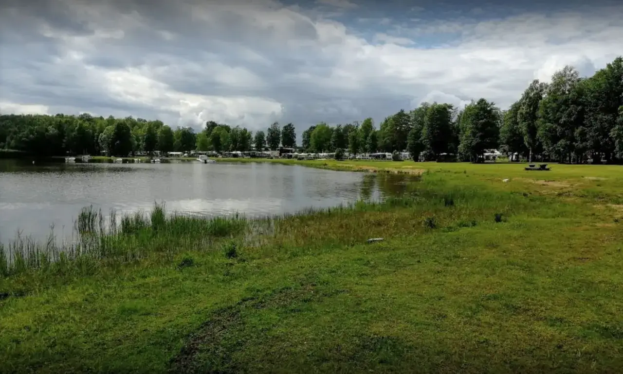 Vacker sjö vid Torsvikens camping med husbilar och träd.
