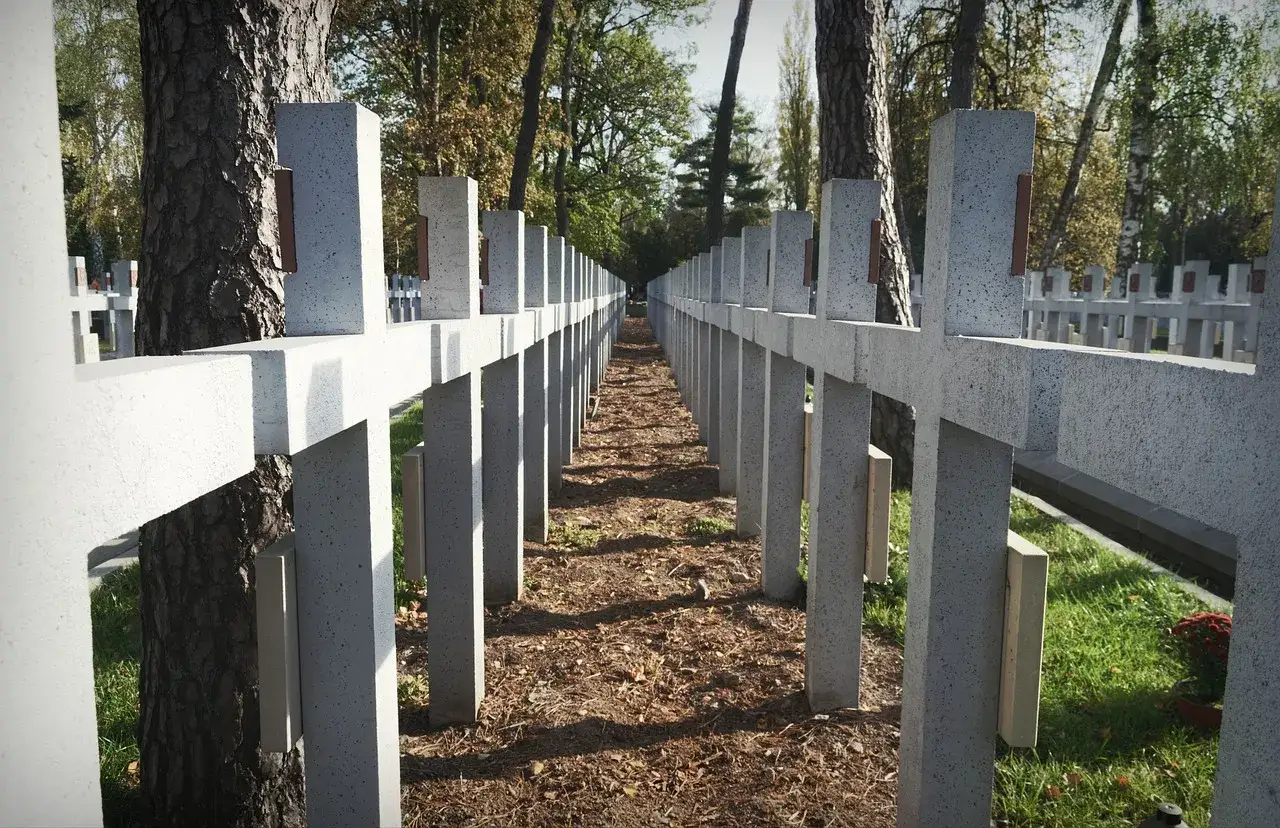 Rząd betonowych krzyży na cmentarzu wojennym, odróżniającym się od cywilnego statusem prawnym i wyglądem.