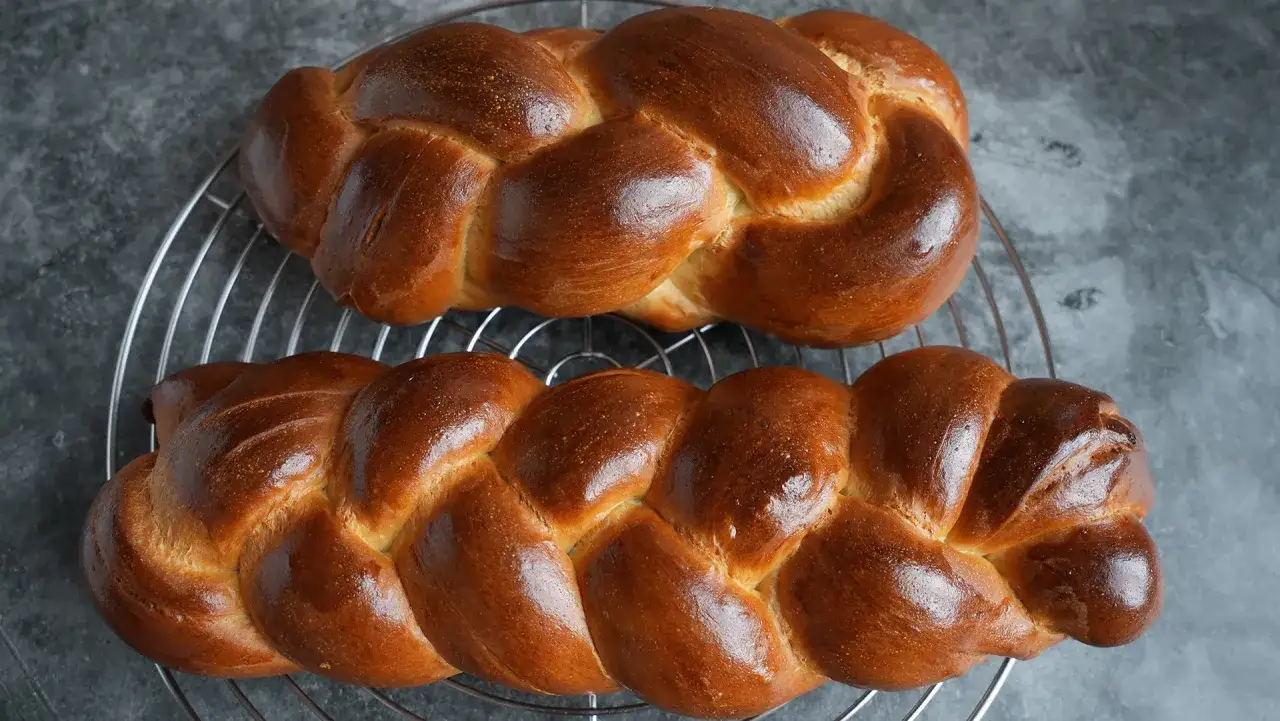Zwei goldbraune Hefez&ouml;pfe auf einem Gitter, bereit zum Genie&szlig;en. Ein perfektes Rezept f&uuml;r Hefezopf!