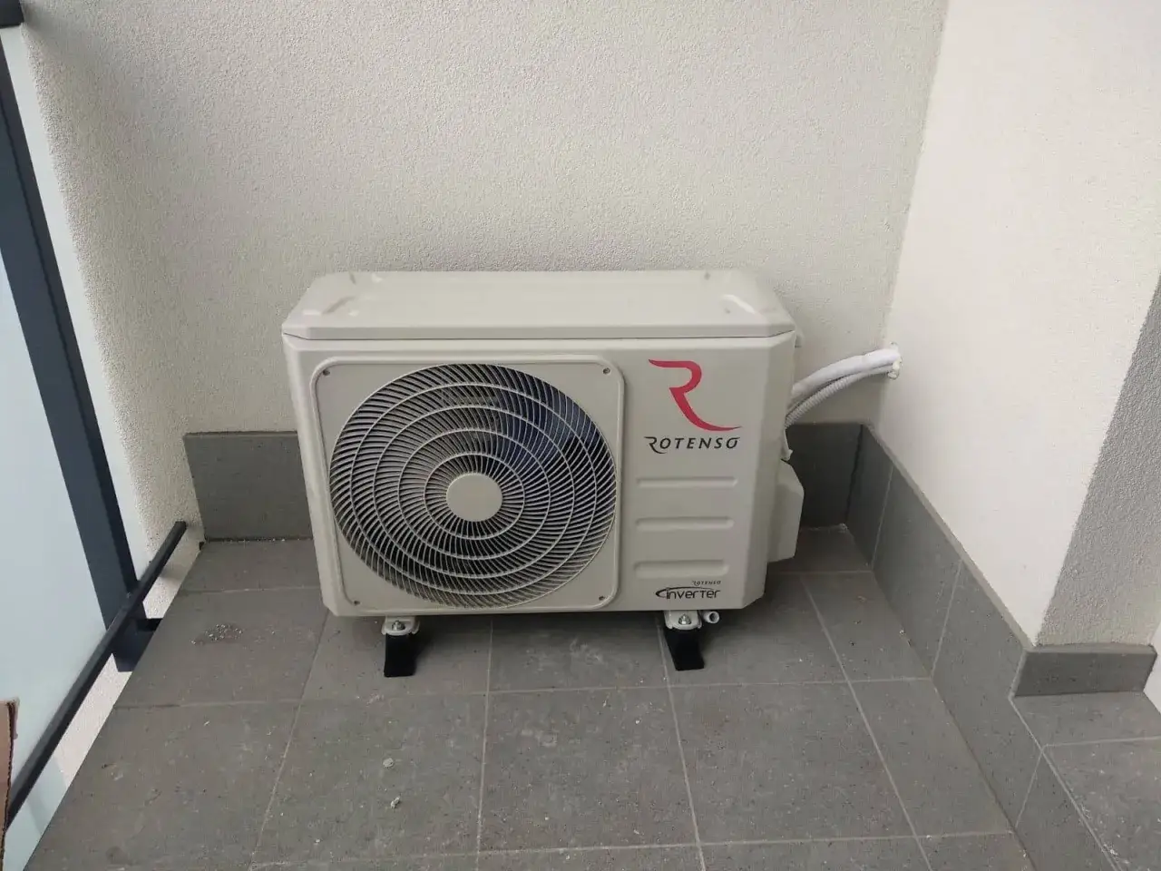 Jednostka zewnętrzna klimatyzatora Rotenso na balkonie.