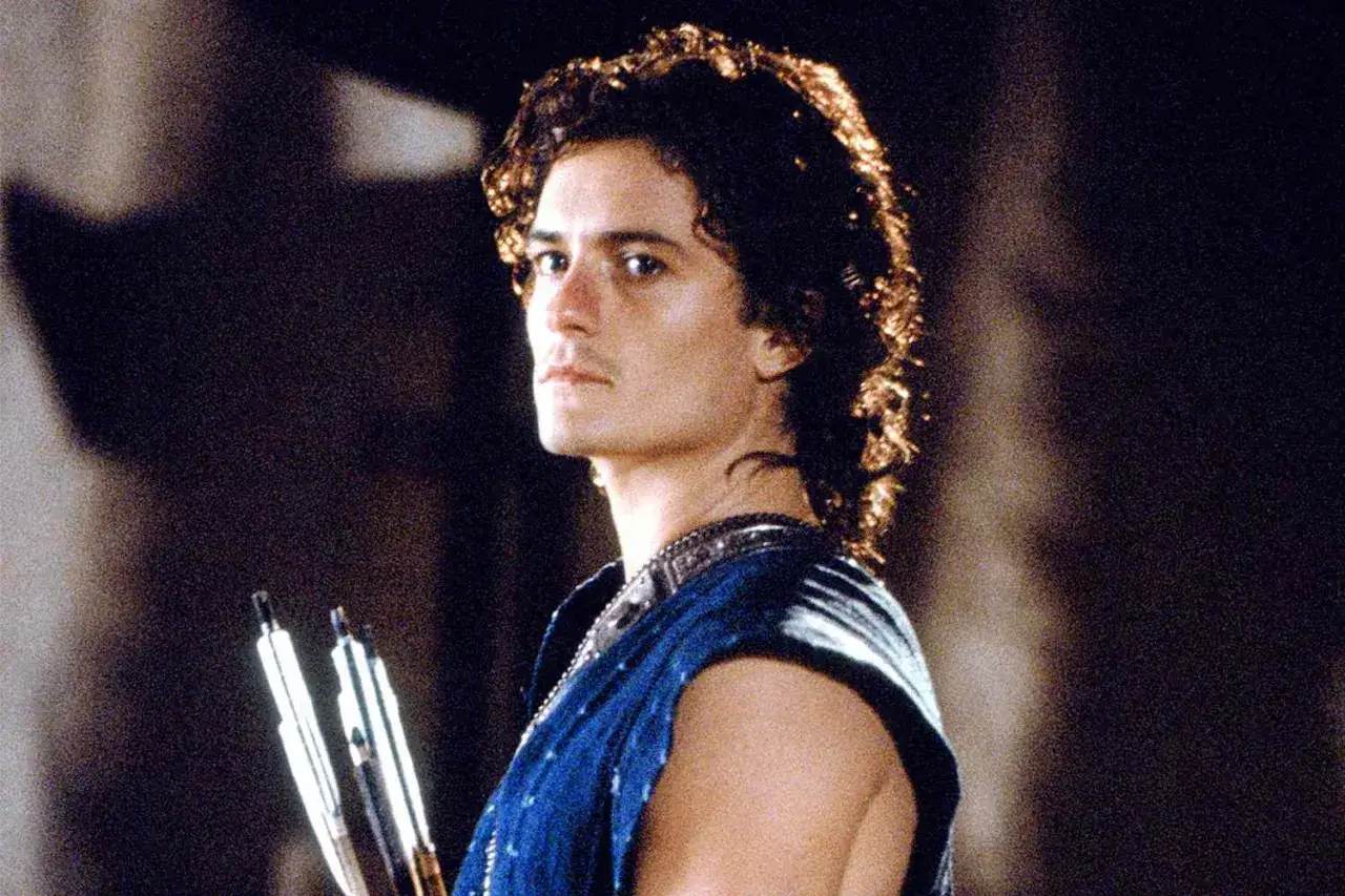 Orlando Bloom w filmach, jako młody wojownik z łukiem i strzałami, gotowy do walki.