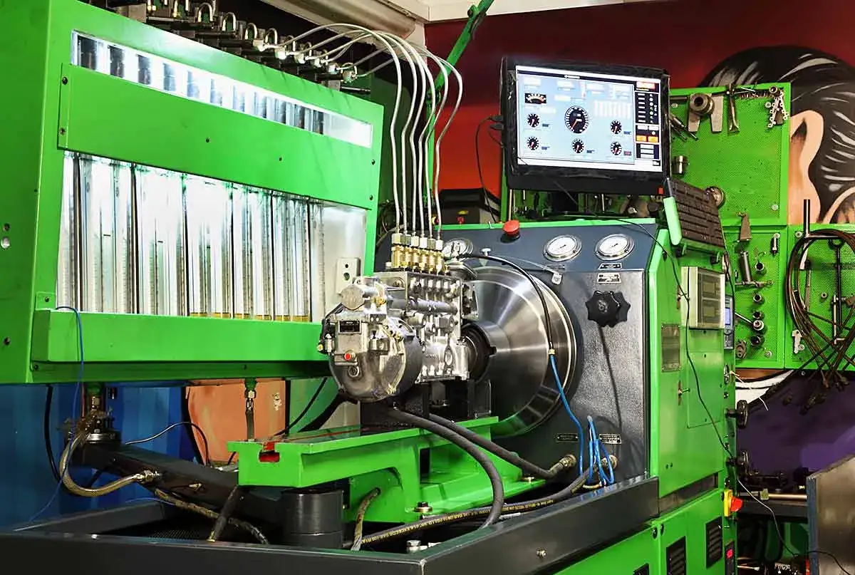 Moderne Pr&uuml;fbank f&uuml;r die **Einspritzpumpe reparieren**. Messzylinder, Computer und die Pumpe sind bereit f&uuml;r den Test.