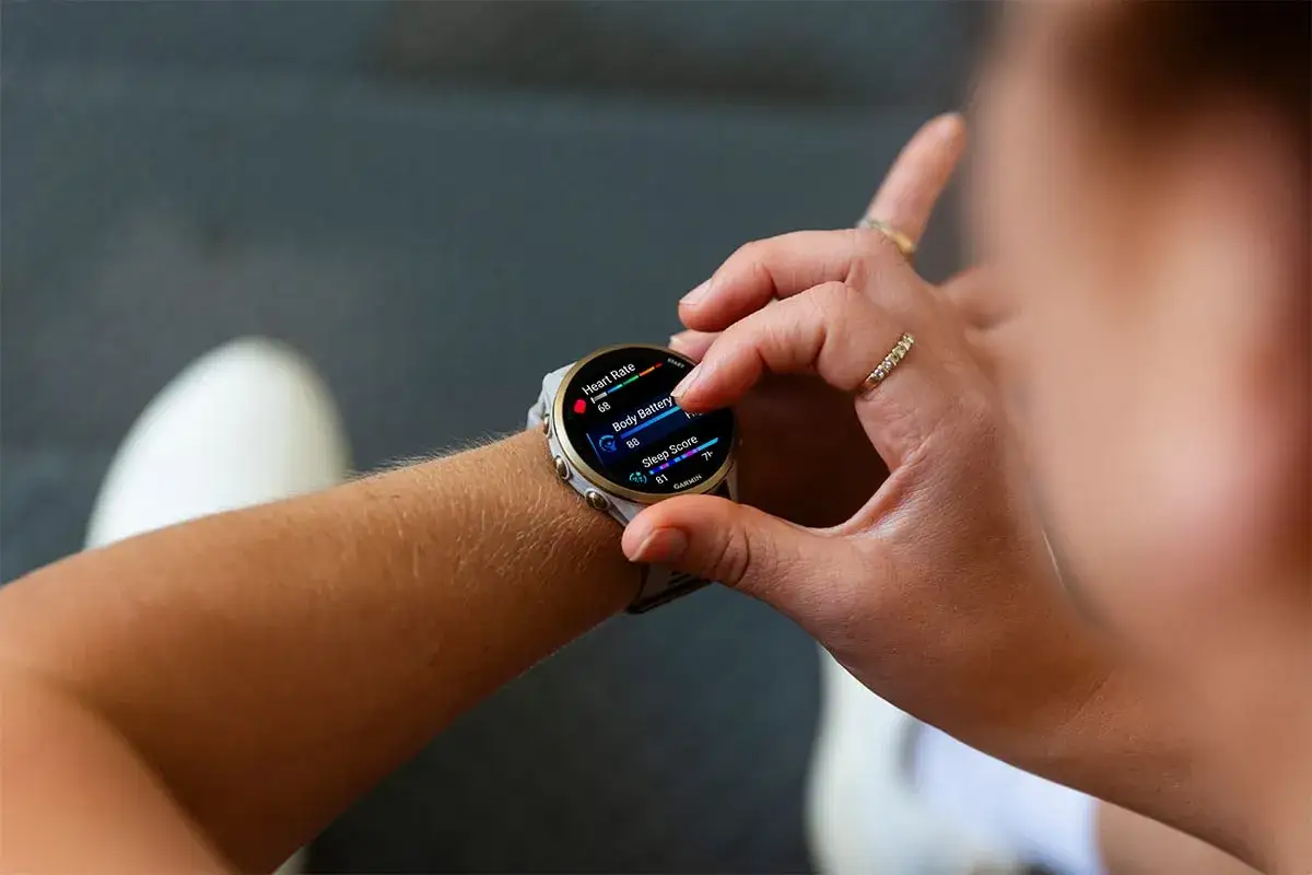 Donna controlla il suo smartwatch per monitorare la frequenza cardiaca, un passo importante per capire come abbassare i battiti cardiaci e migliorare il benessere.