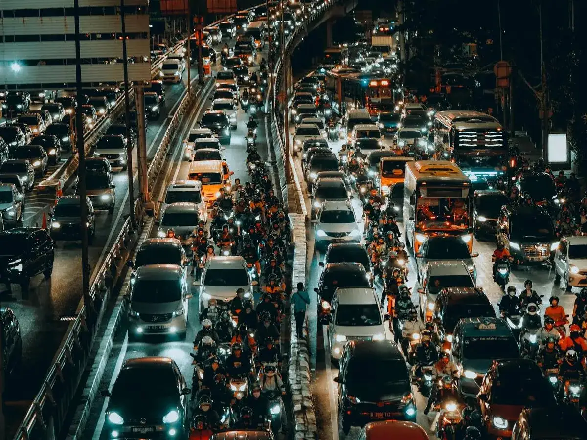 Atasoche de vehículos y motocicletas en una autopista nocturna, un ejemplo de la compleja movilidad urbana.