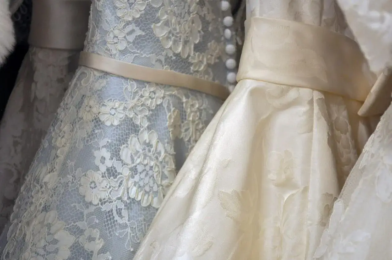 Detalles de un ajuar de novia: vestidos con encaje floral y cintas de satén, listos para el gran día.