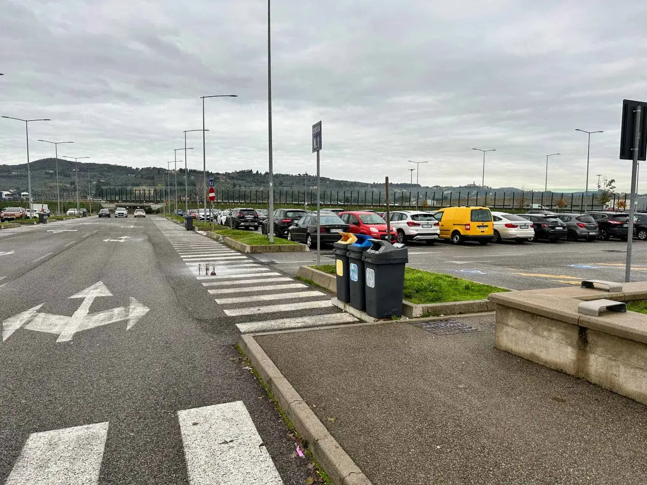 Parking lot with cars and streetlights. Do you need a car in Florence? This lot suggests it's an option.