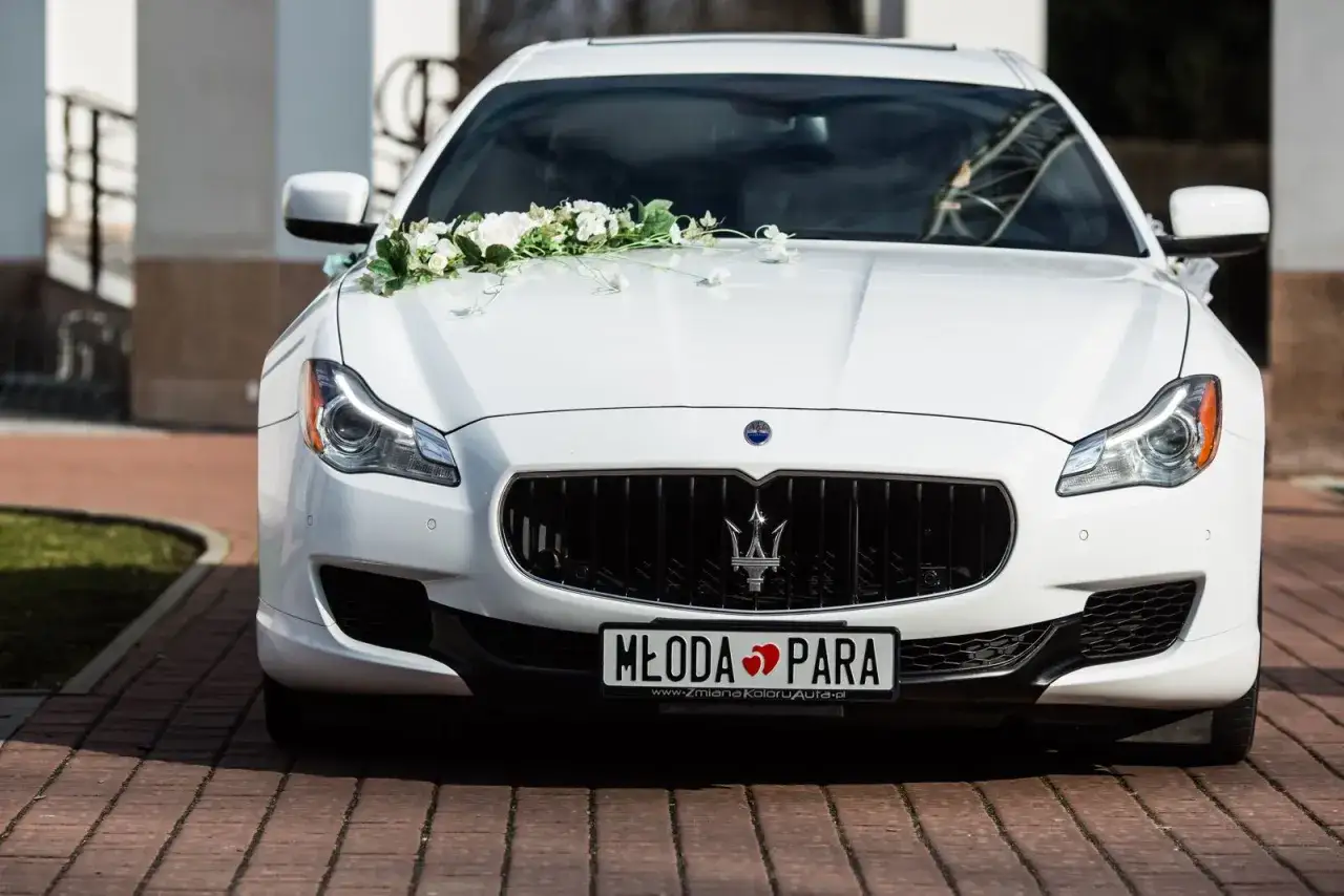 Biały Maserati ozdobiony kwiatami, z tablicą