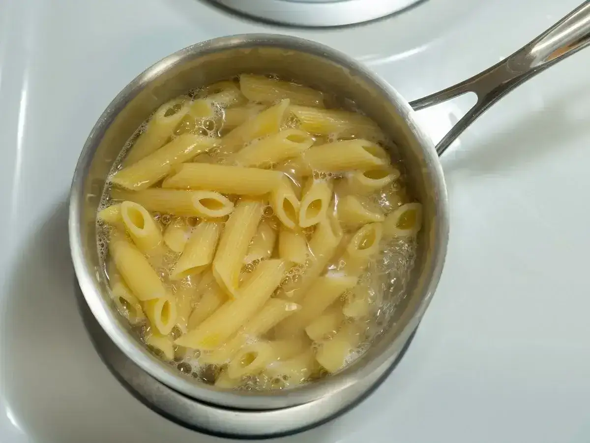 Penne rigate gotują się w garnku na kuchence.