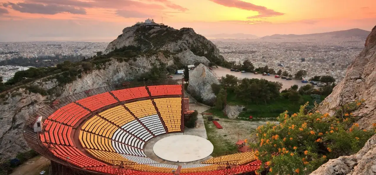 Widok na amfiteatr i panoramę Aten ze wzgórza Lycabettus o zachodzie słońca.