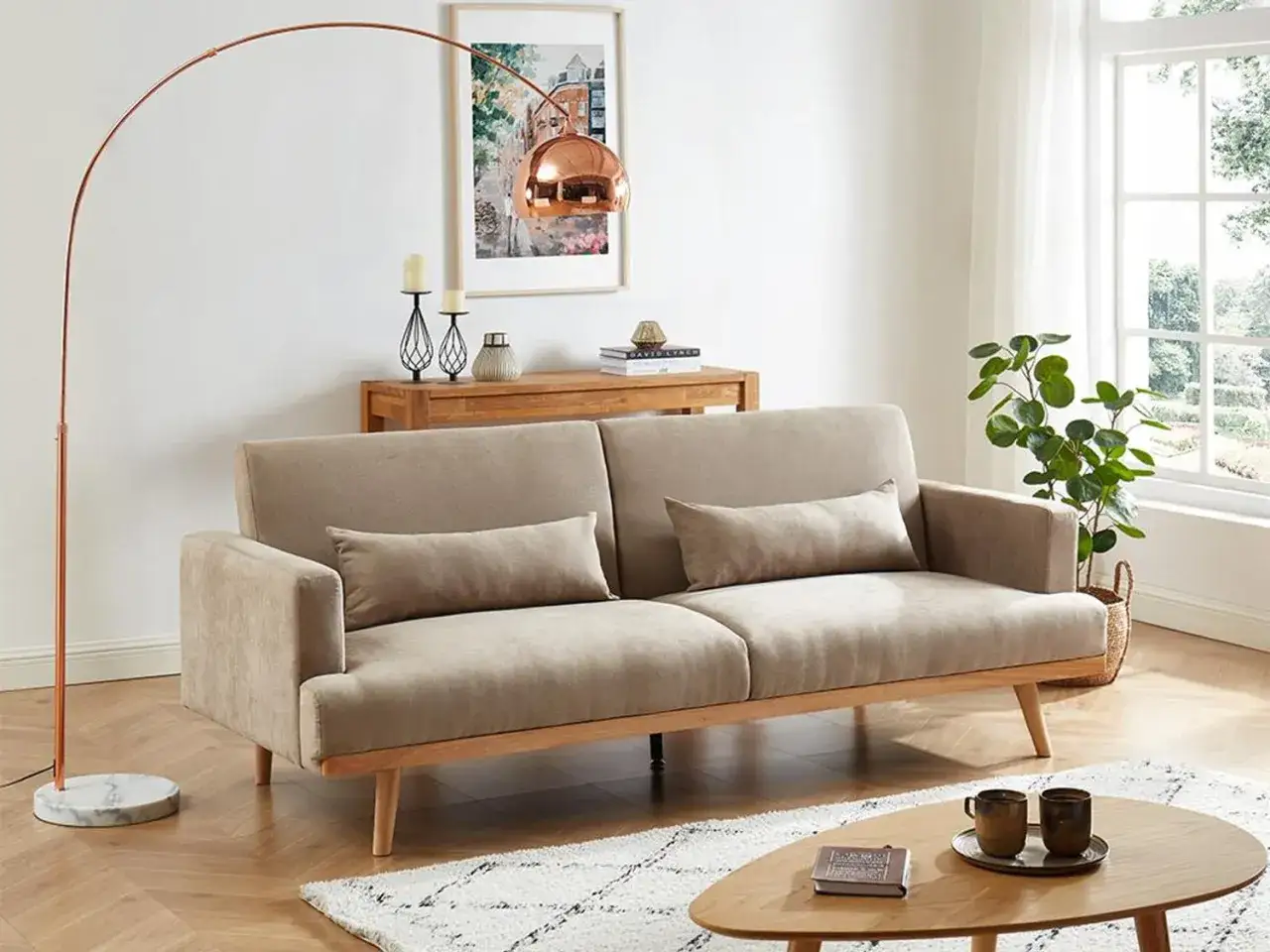 En ljus soffa med tr&auml;detaljer, en kopparlampa och en tavla. En tidl&ouml;s design klassiker som skapar en mysig atmosf&auml;r.