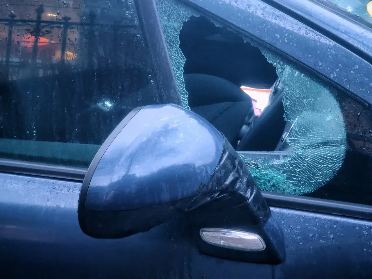 Fen&ecirc;tre bris&eacute;e d'une voiture, t&eacute;moin d'un vol &agrave; la roulotte. Le r&eacute;troviseur est aussi endommag&eacute;.