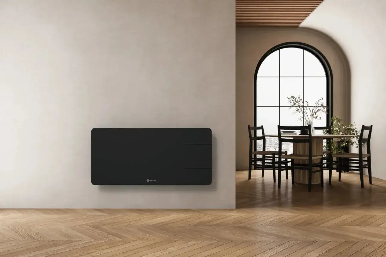 Calentador negro moderno en pared, ideal para saber como calentar una casa económicamente. Comedor con mesa y sillas al fondo.