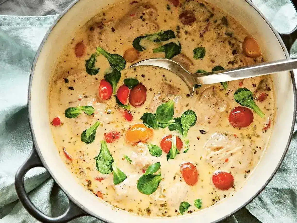 Kr&auml;mig kycklinggryta med k&ouml;rsb&auml;rstomater och gr&ouml;na blad. Ett enkelt kyckling recept som ser uts&ouml;kt ut.