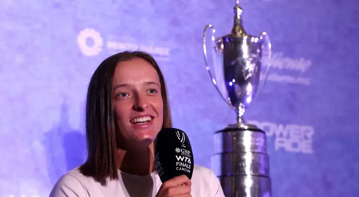 Iga Świątek z mikrofonem i pucharem WTA Finals w Cancun. Kolejne z jej wielkich osiągnięć.