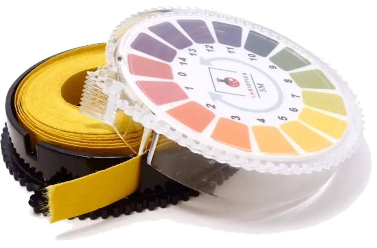 Ein Rollenhalter mit gelbem Testpapier und einer farbigen PH-Wert-Skala zur Bestimmung des Säuregrads.