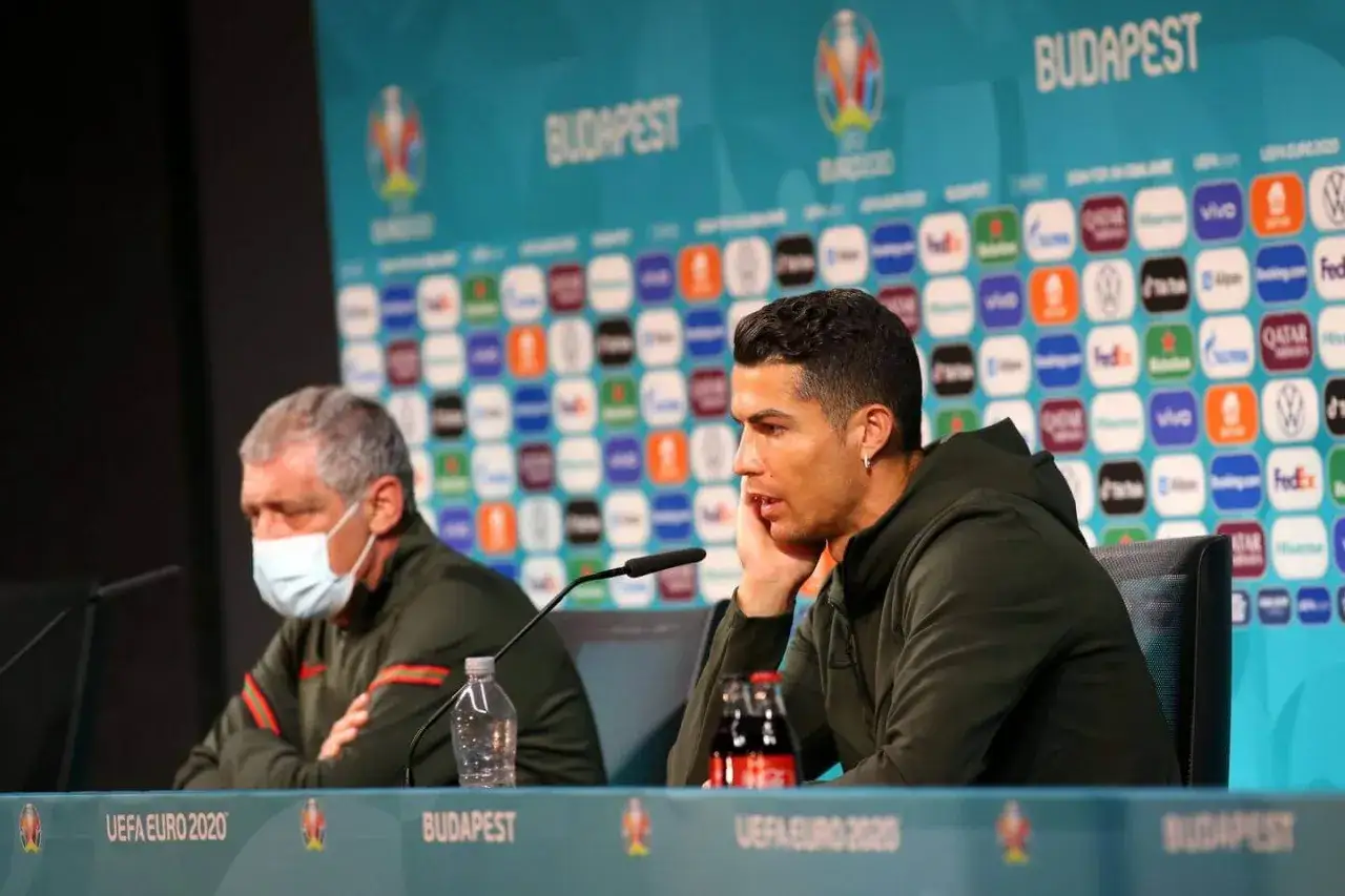 Cristiano Ronaldo podczas konferencji prasowej, obok butelka Coca-Cola.