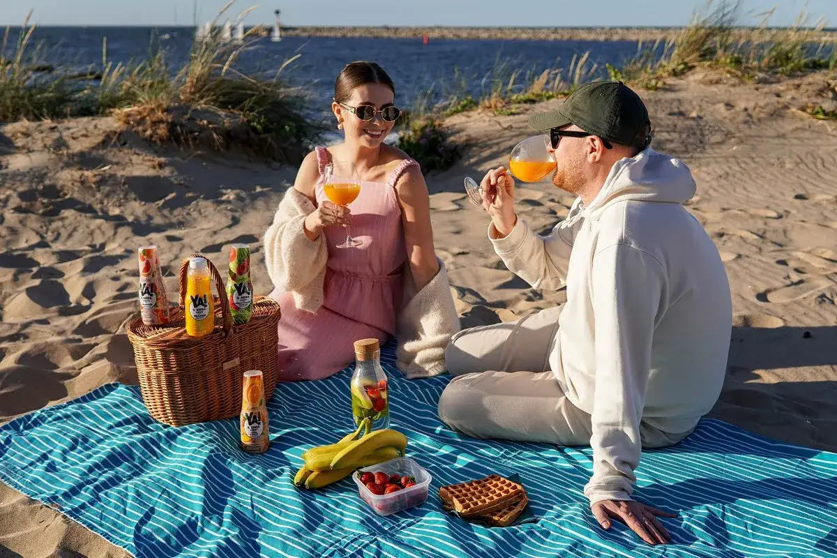 Para piknik na plaży: koszyk z napojami, owoce, gofry i dobra zabawa. Idealne rzeczy, co zabrać na piknik.