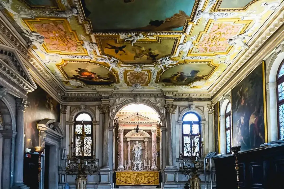 Interno sontuoso con soffitto affrescato e altare con statua. Un esempio delle tante mostre da vedere a Venezia.