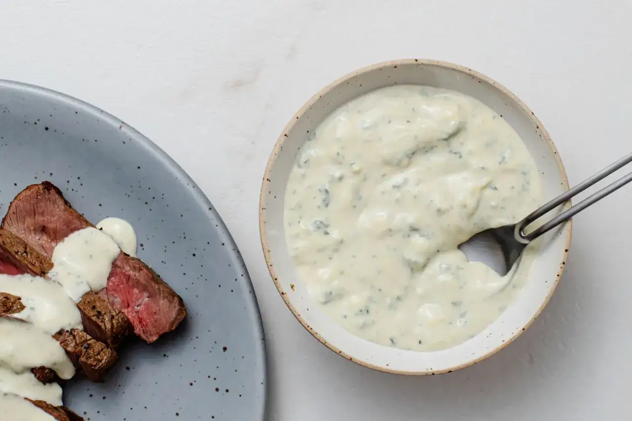 Solomillo jugoso bañado en una cremosa salsa de queso azul, lista para ser servida.