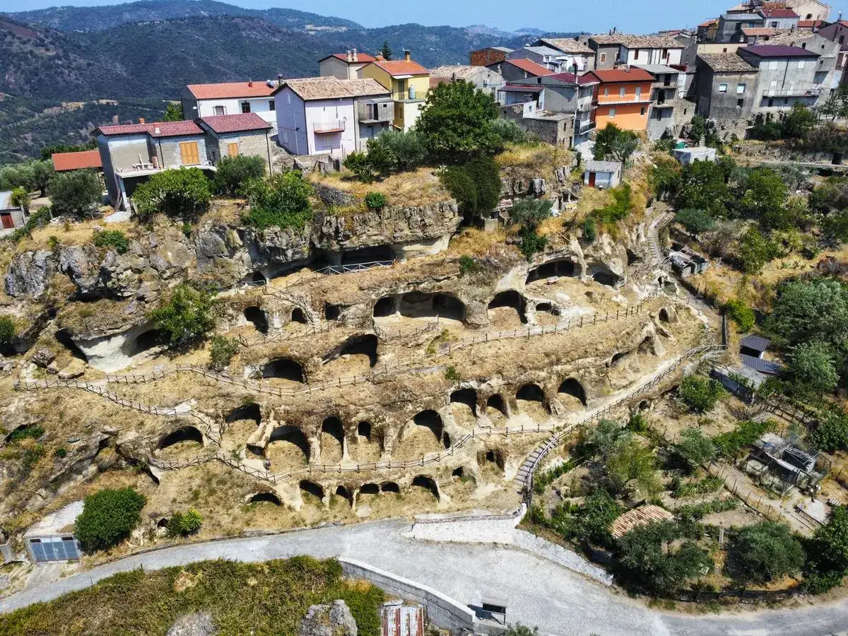 Antiche abitazioni rupestri scavate nella roccia sul Monte Poro, Calabria. Un villaggio arroccato tra le colline verdi.