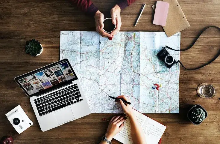 osoba planująca podr&oacute;ż mapa laptop