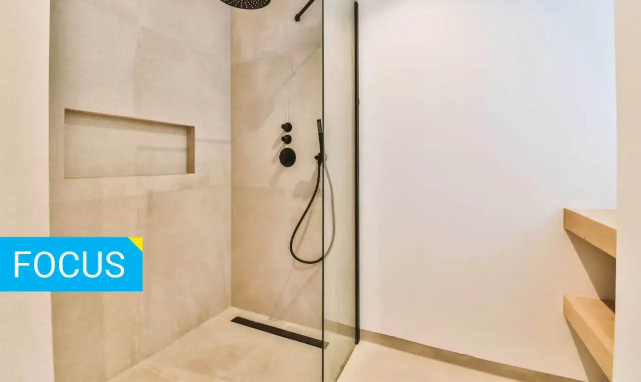 Doccia moderna con pareti in finto marmo e nicchia a muro. Il soffitto &egrave; in cartongesso, creando un ambiente elegante e funzionale.
