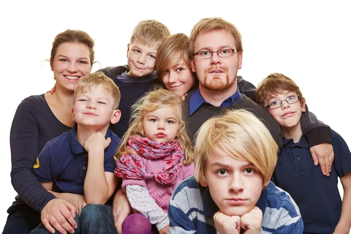 Szczęśliwa mama 4 plus dzieci, uśmiechnięta z rodziną, pozuje do zdjęcia.