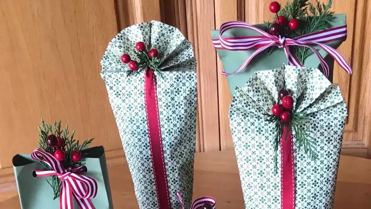 Mehrere flaschen als geschenk verpacken: festlich geschmückte Präsente mit roten Beeren und Tannenzweigen.
