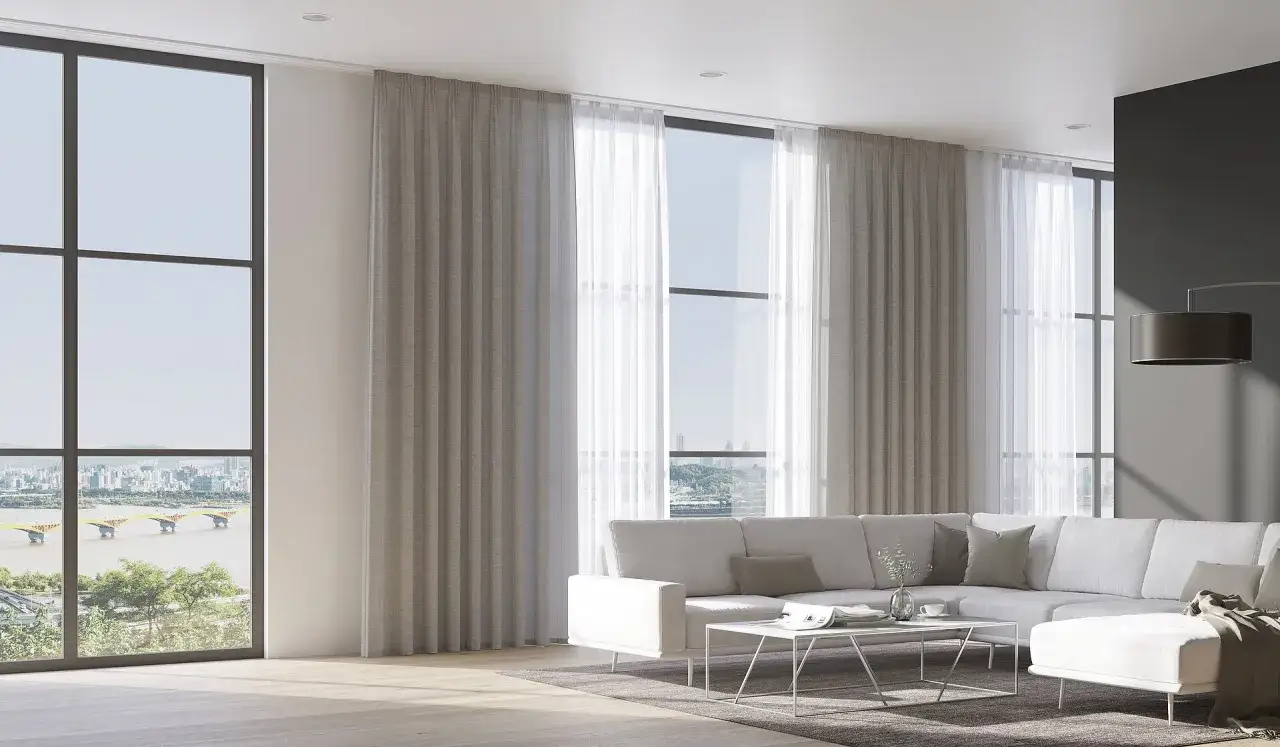 Moderne Wohnzimmer mit großen Fenstern, durch die man eine Stadt mit Brücke sieht. Helle Vorhänge hängen an einer unsichtbaren Gardinenschiene oder Stange.
