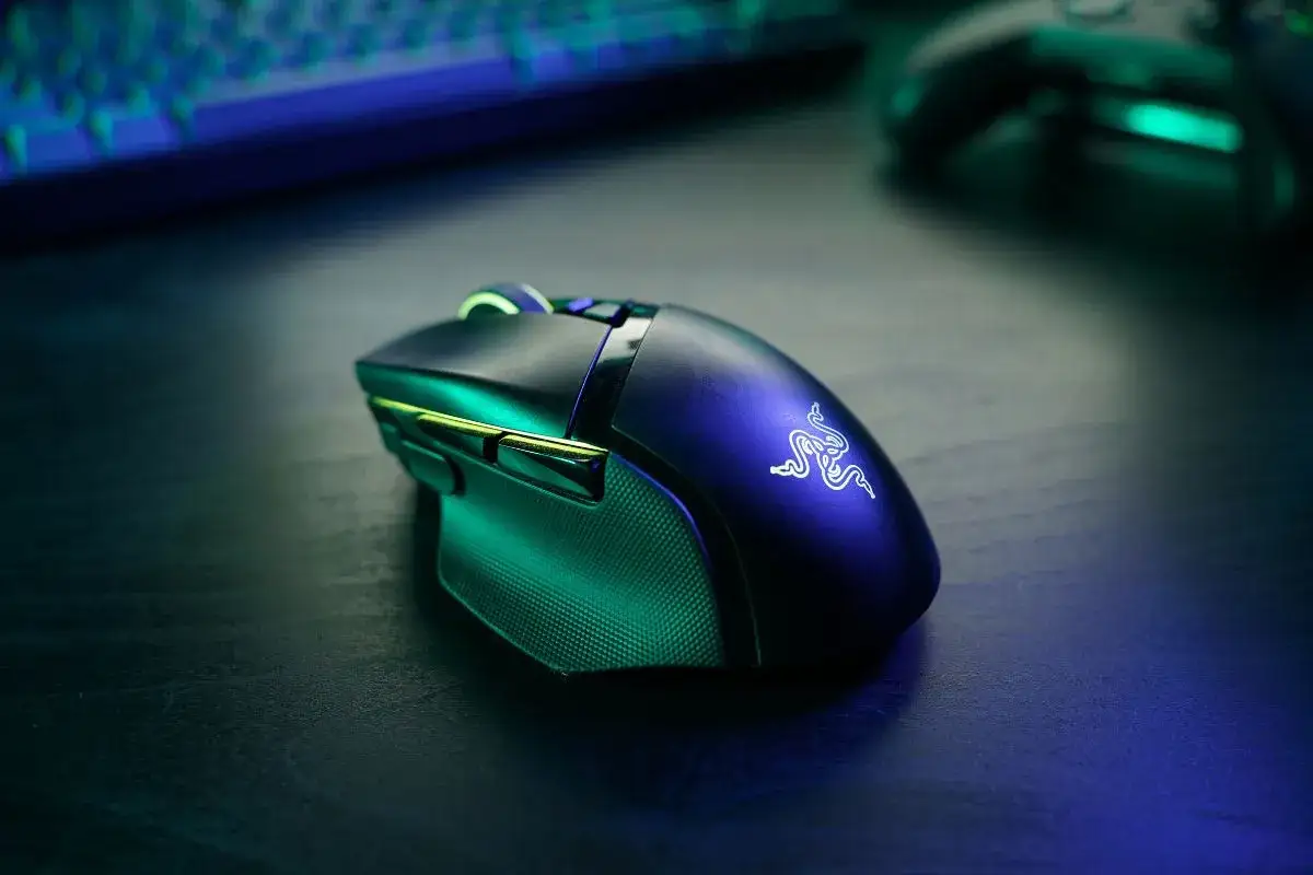 Czarna myszka bezprzewodowa Razer z podświetleniem RGB, która nie działa, leży na ciemnym blacie.