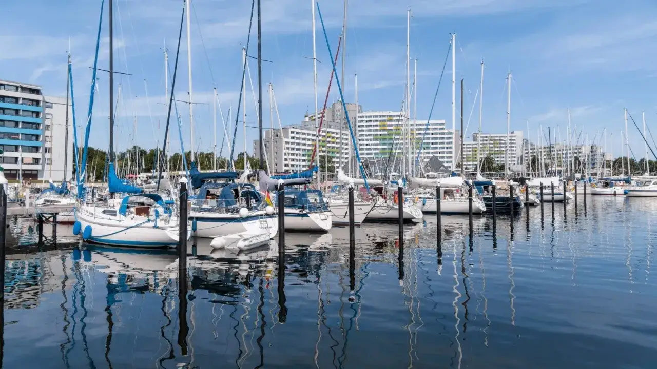 Viele Segelboote liegen im **damp Hafen** vor Anker. Im Hintergrund erheben sich moderne Geb&auml;ude.