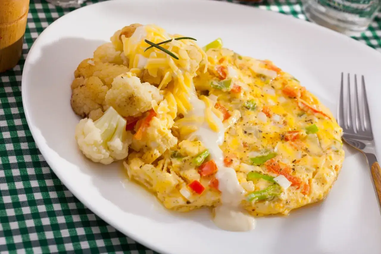 Pyszny omlet z warzywami i serem, podany z kalafiorem. Świetny pomysł, co zrobić z białek, gdy masz ochotę na lekkie śniadanie.