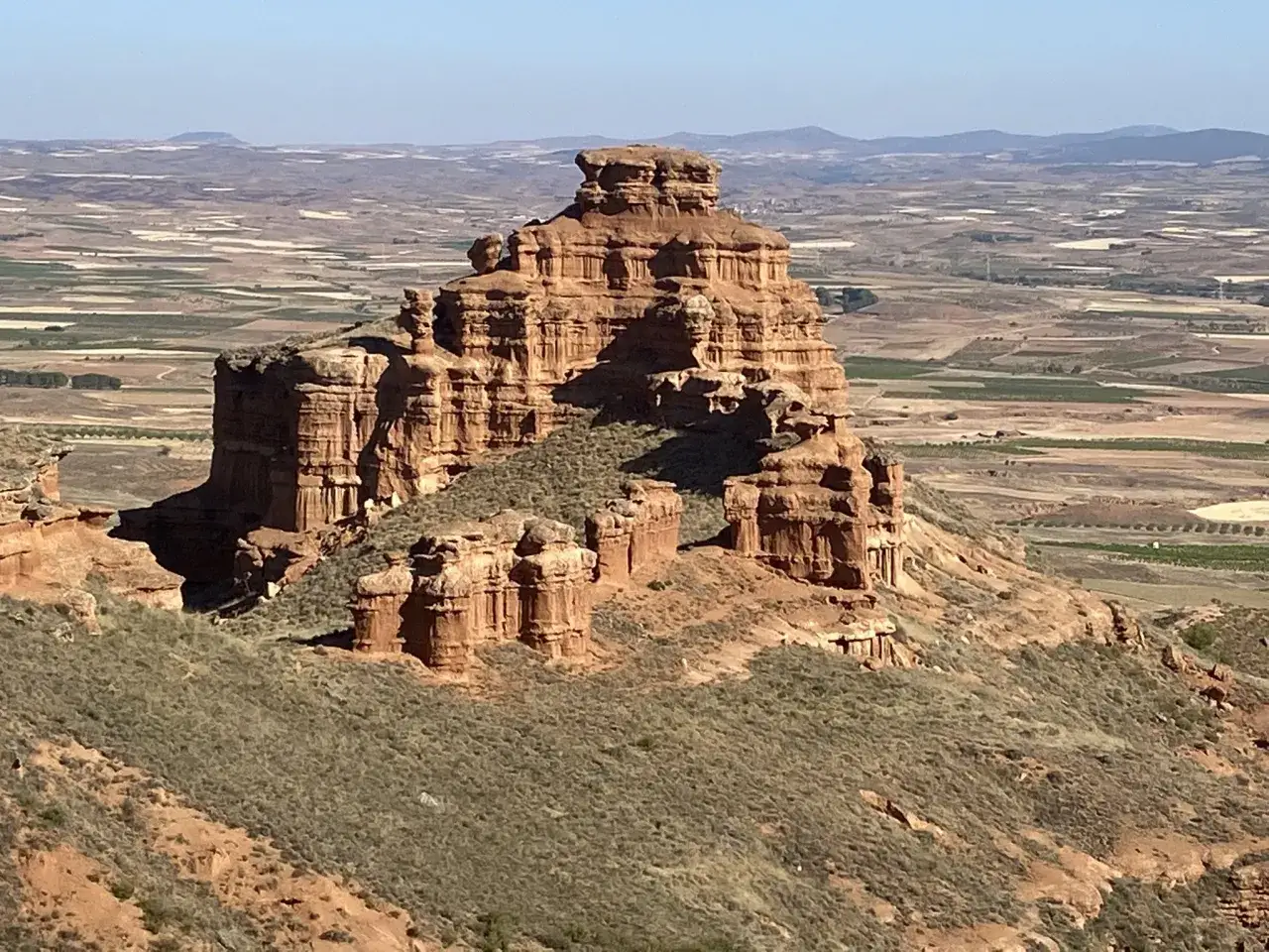 Impresionante formaci&oacute;n rocosa en Villarroya de la Sierra, con el valle y campos cultivados al fondo.