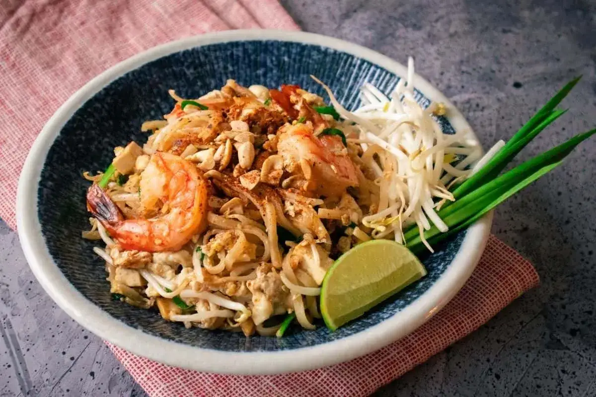 Pad thai z krewetkami, kiełkami i limonką, polany pysznym pad thai sosem.
