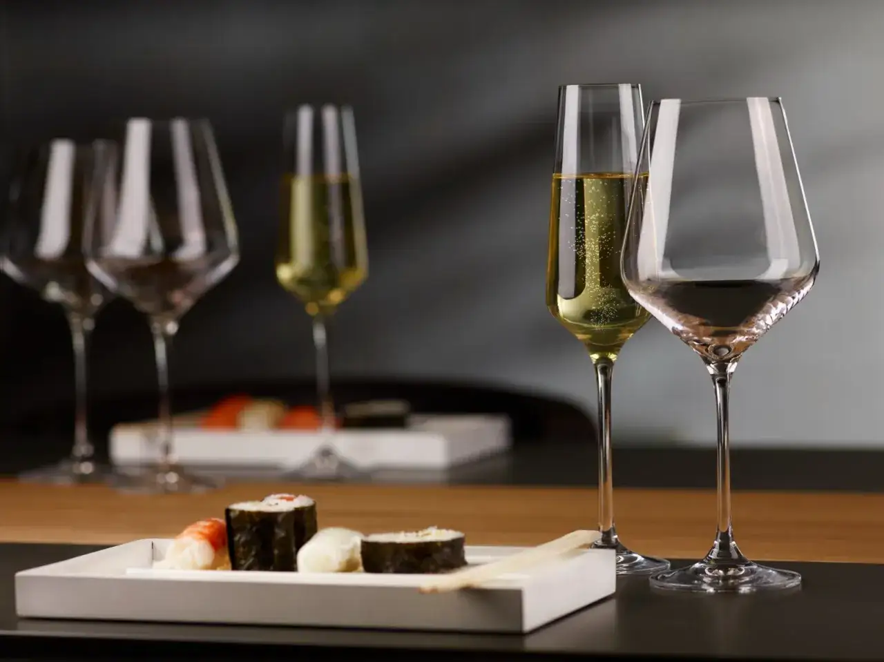 Eleganckie kieliszki z szampanem i winem, idealne do sushi. Pyszne jedzenie i wykwintne trunki - co pić do sushi?