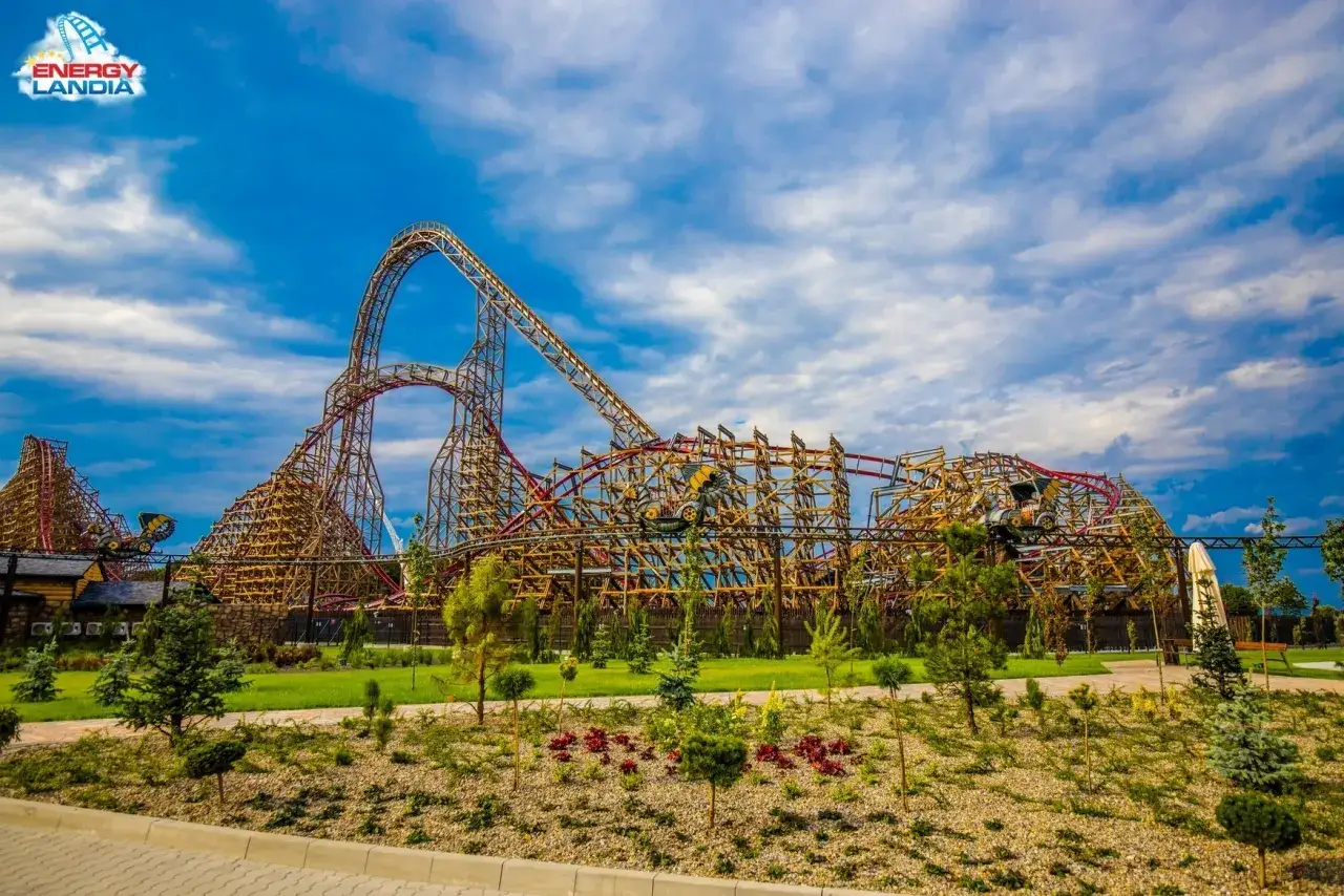 Największy drewniany rollercoaster na świecie w Energylandii, z imponującymi drewnianymi konstrukcjami i niebieskim niebem.