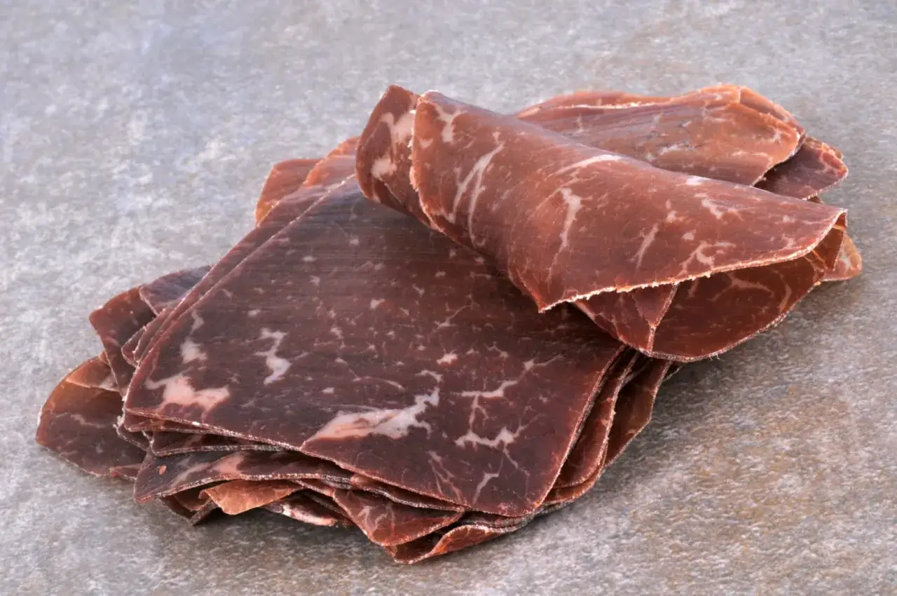 Fines tranches de viande de grison, d'une belle origine, aux marbrures blanches caractéristiques.