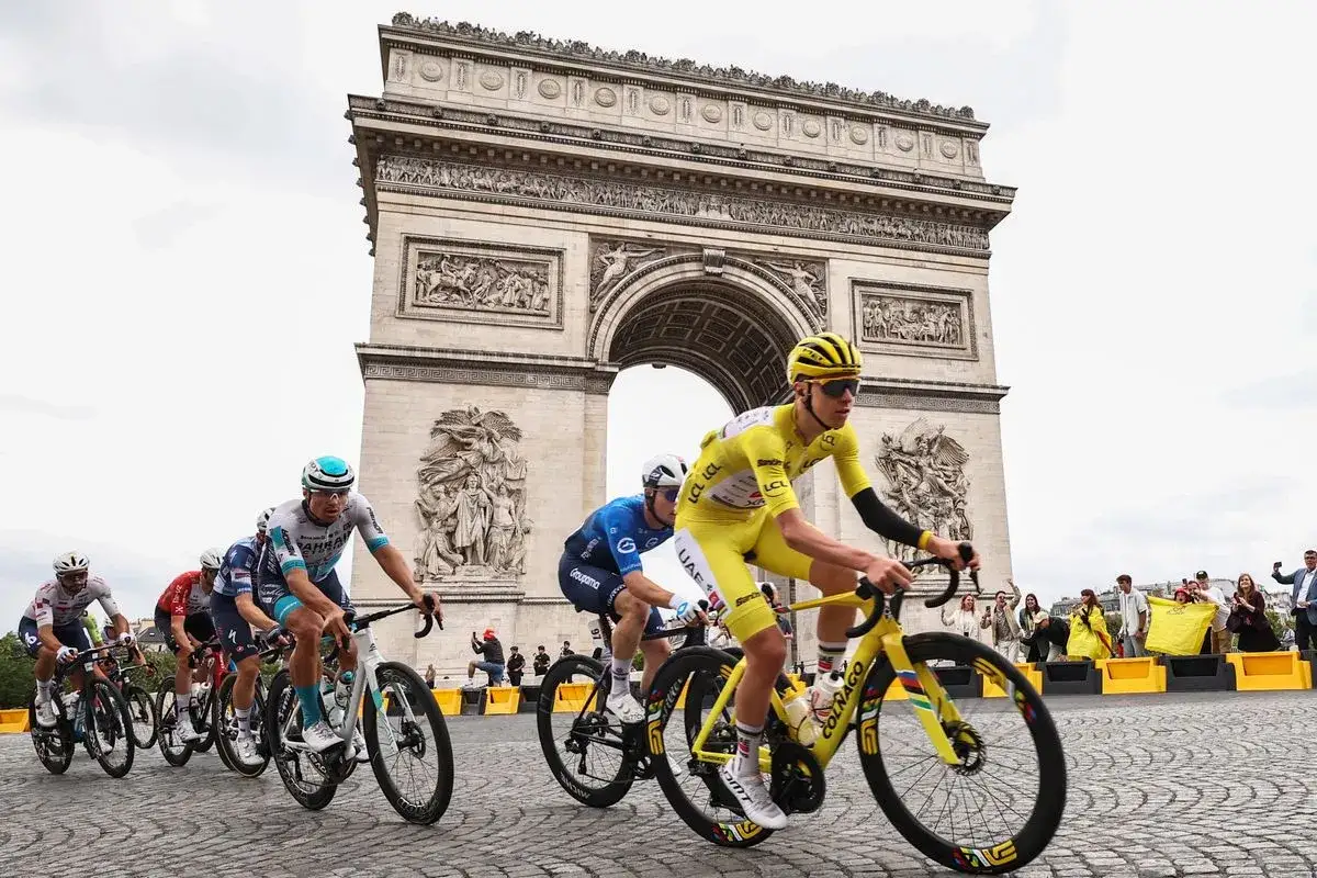 Cyclists race towards the Arc de Triomphe, a scene from le grand tour de France.