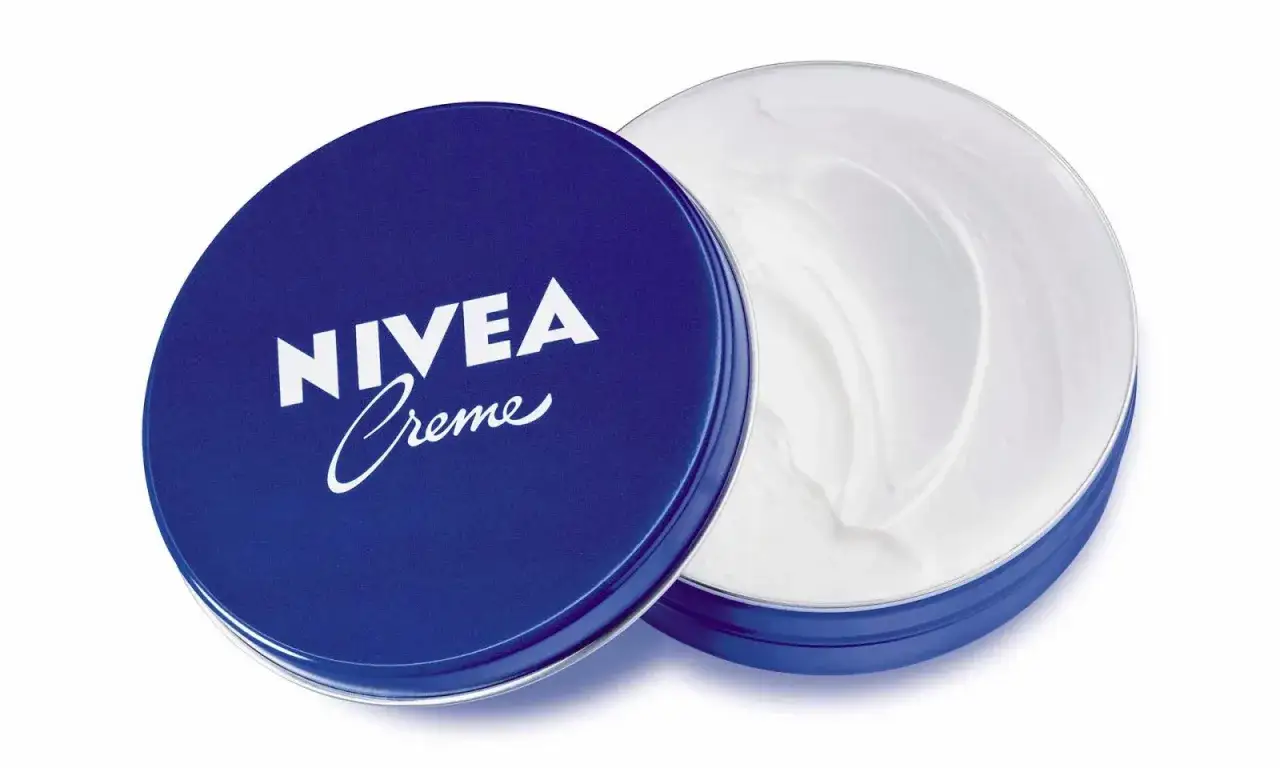 Bo&icirc;te ouverte de cr&egrave;me Nivea bleue, r&eacute;v&eacute;lant sa texture onctueuse. D&eacute;couvrez les bienfaits de cette cr&egrave;me iconique pour une peau hydrat&eacute;e.