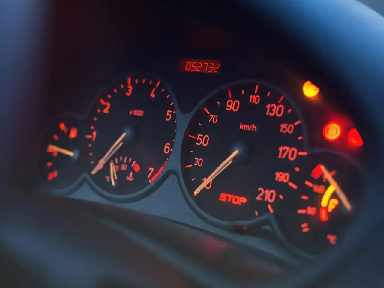 Deska rozdzielcza Skoda z podświetlanymi na czerwono wskaźnikami: prędkościomierzem, obrotomierzem i wskaźnikiem paliwa.