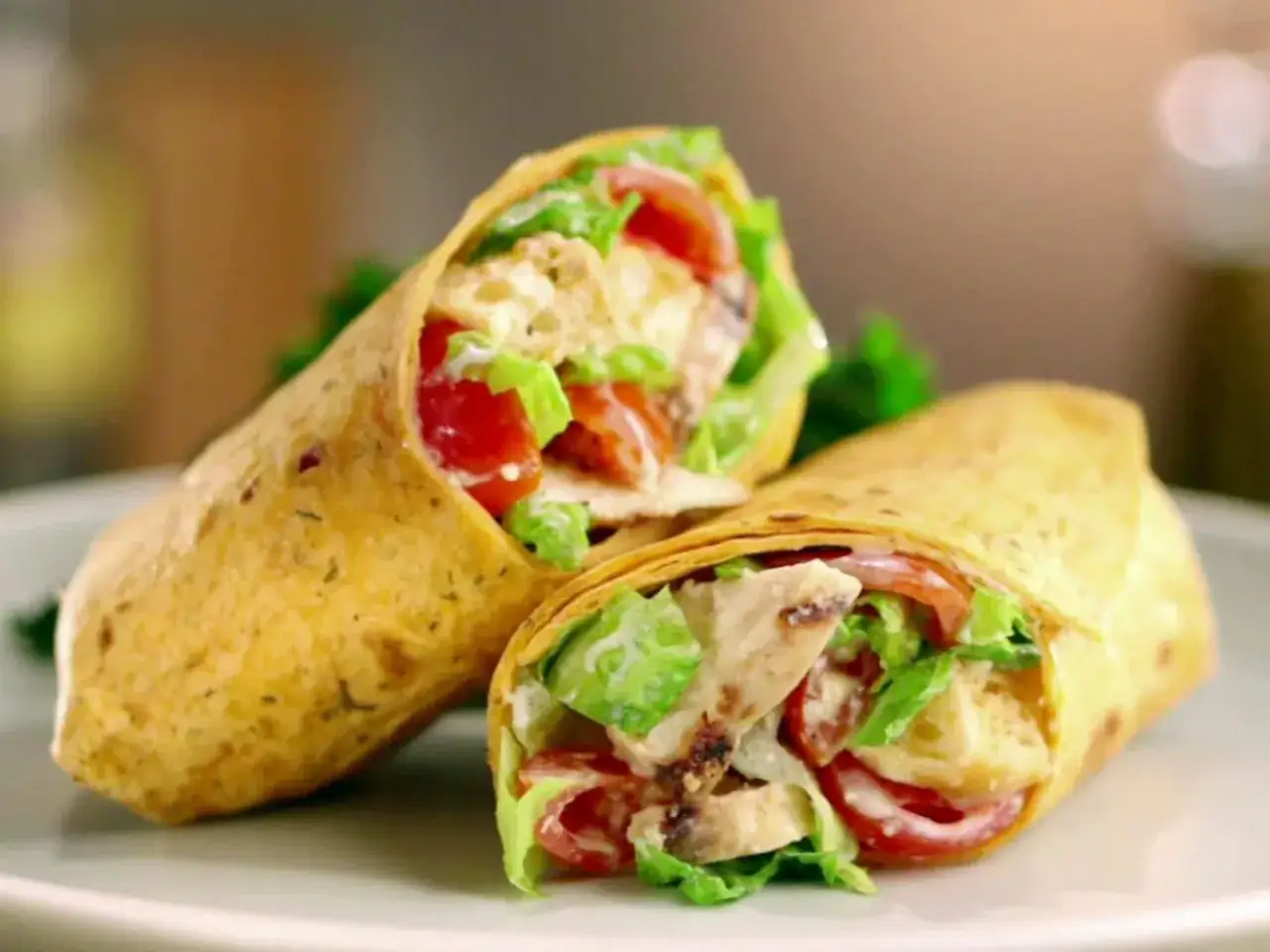 Dwa pyszne mcwrap grillowany kurczak z chrupiącą sałatą i pomidorami, zawinięte w złocisty placek.