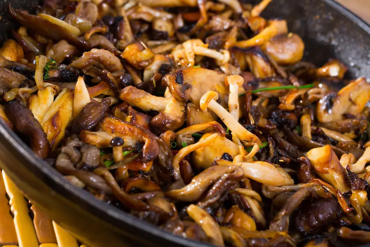 Setas al ajillo en sartén, doradas y jugosas, con trozos de ajo y perejil fresco. Un plato sencillo y delicioso.