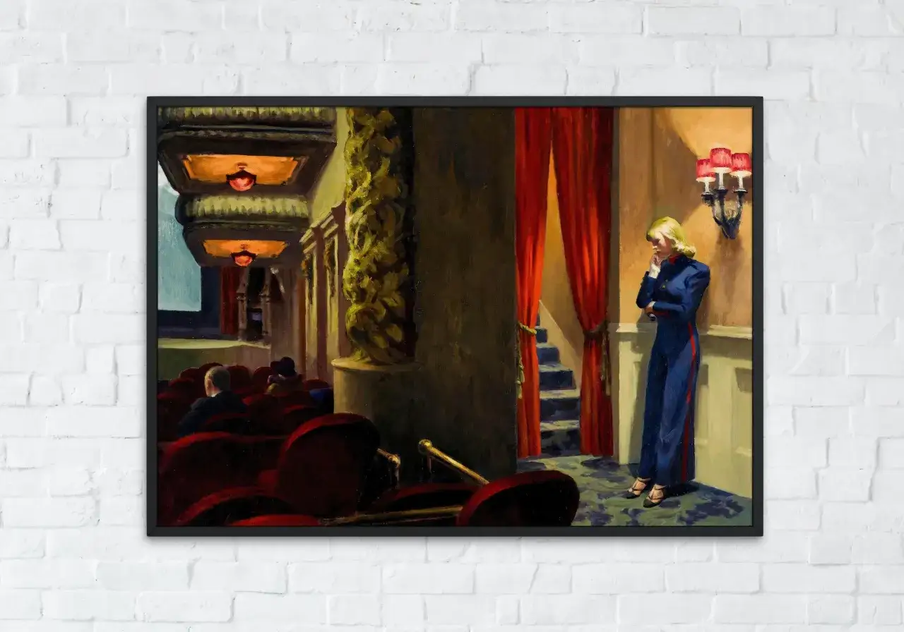 Un tableau d'Edward Hopper : une femme en tenue bleue attend seule dans un théâtre vide, les fauteuils rouges sombres contrastent avec les rideaux écarlates.