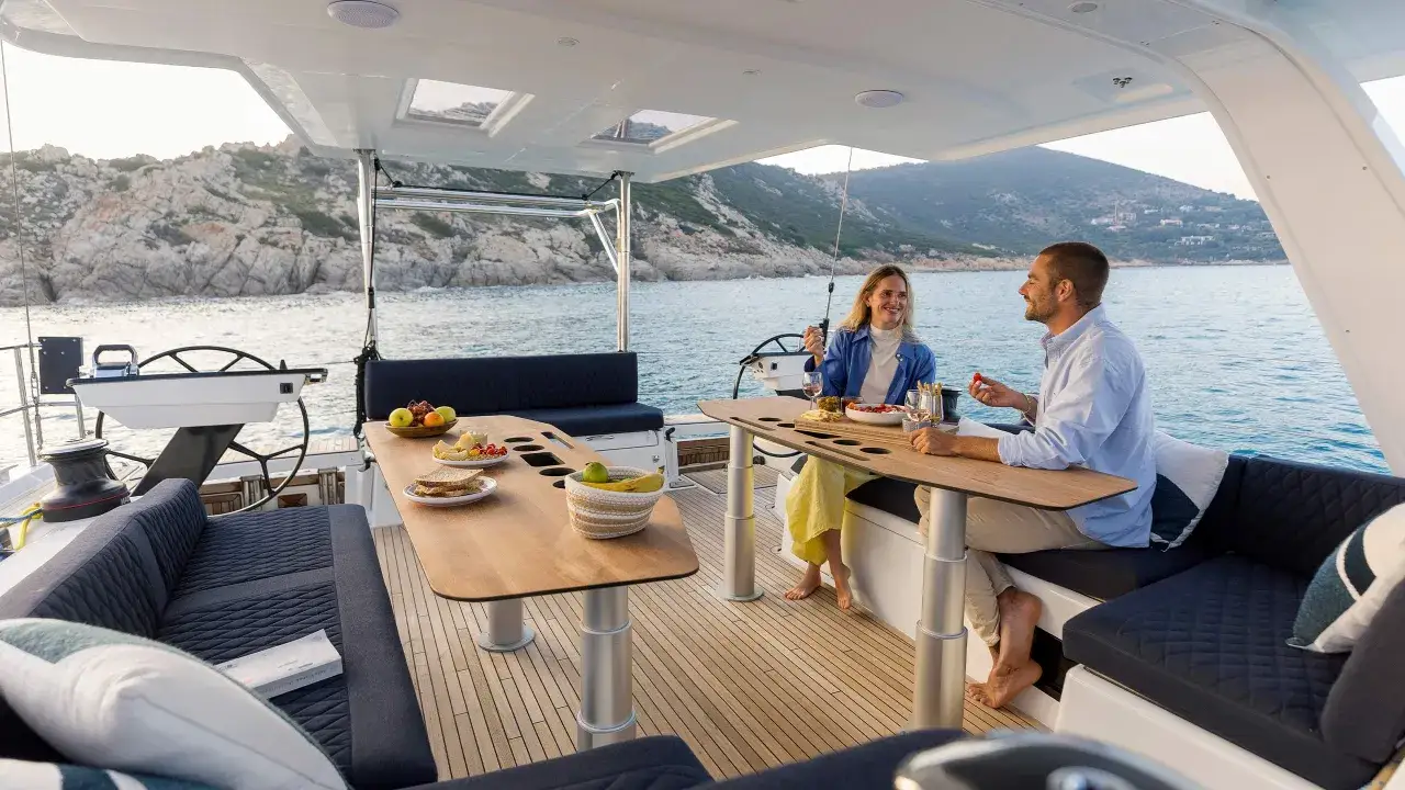 Couple profitant d'un moment de détente sur le Dufour Duo 26, avec vue sur la côte rocheuse.