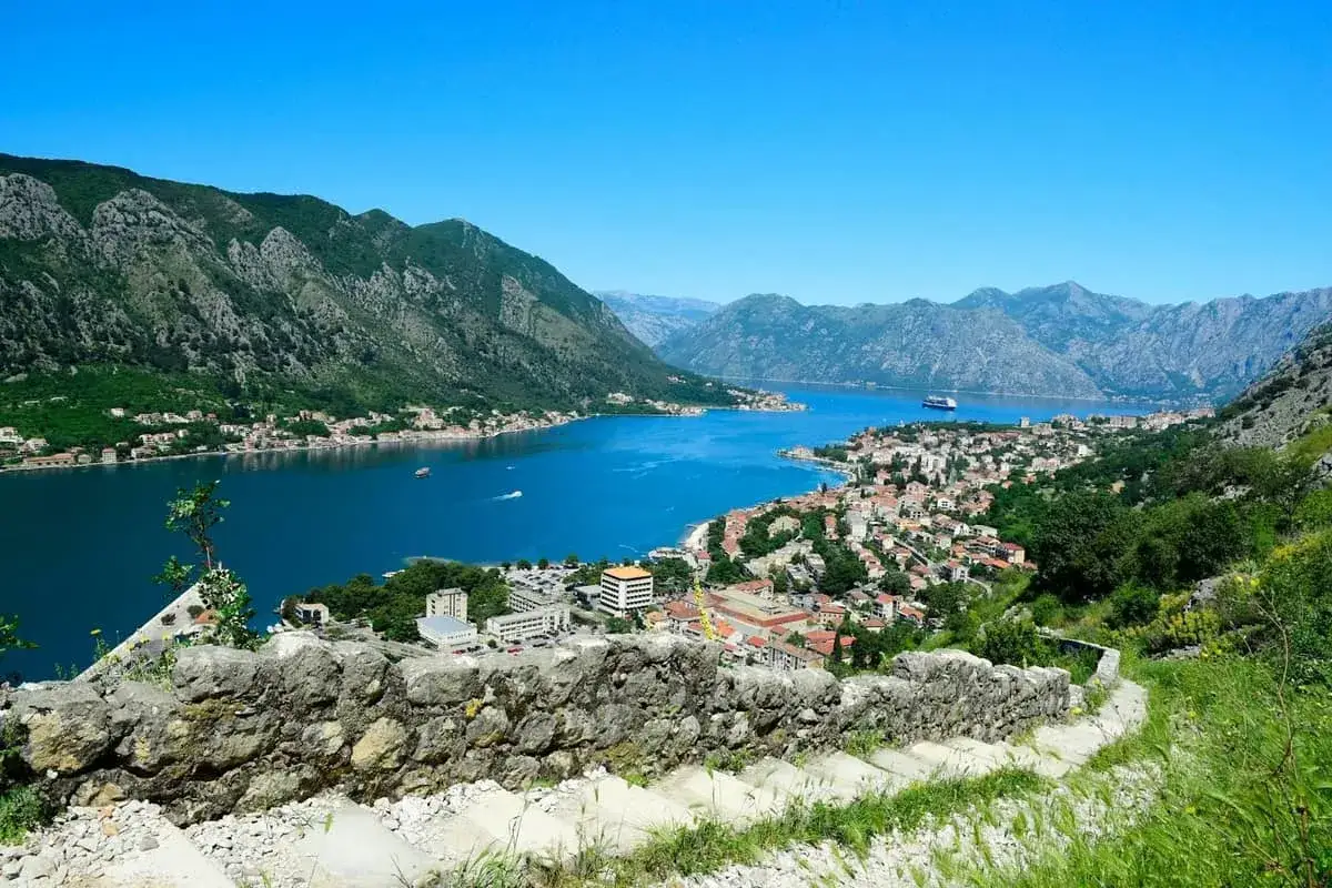 Widok na Zatokę Kotorską, miasto z czerwonymi dachami i góry. Warto zobaczyć Kotor!