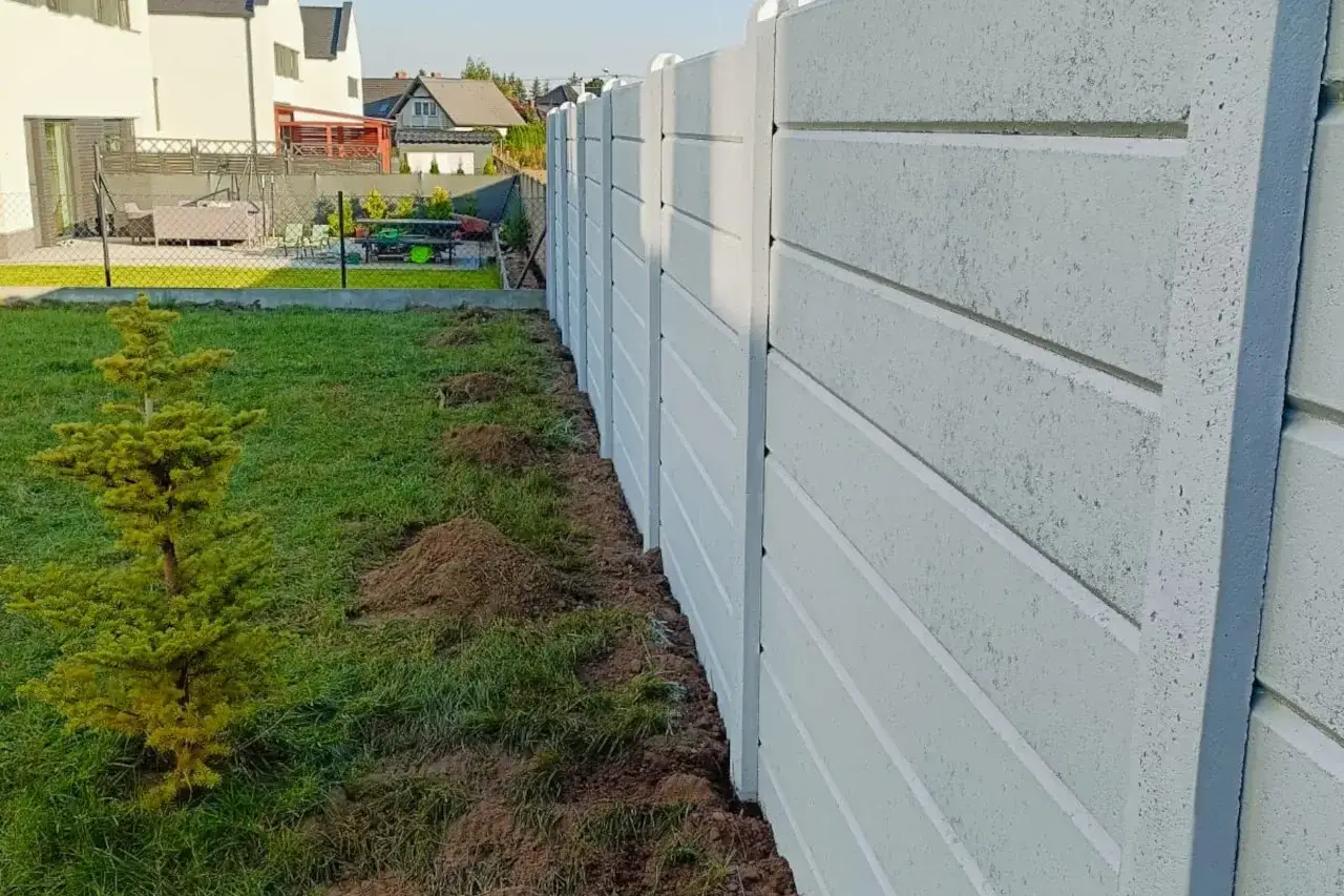 Nowy betonowy płot czeka na aranżację. Zastanawiasz się, jak upiększyć betonowy płot? Posadź pnącza lub ozdobne krzewy przy nim.